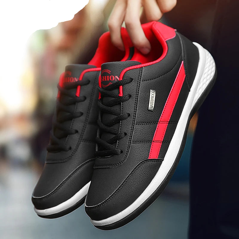 Black and red sneakers with white soles held by a hand.
