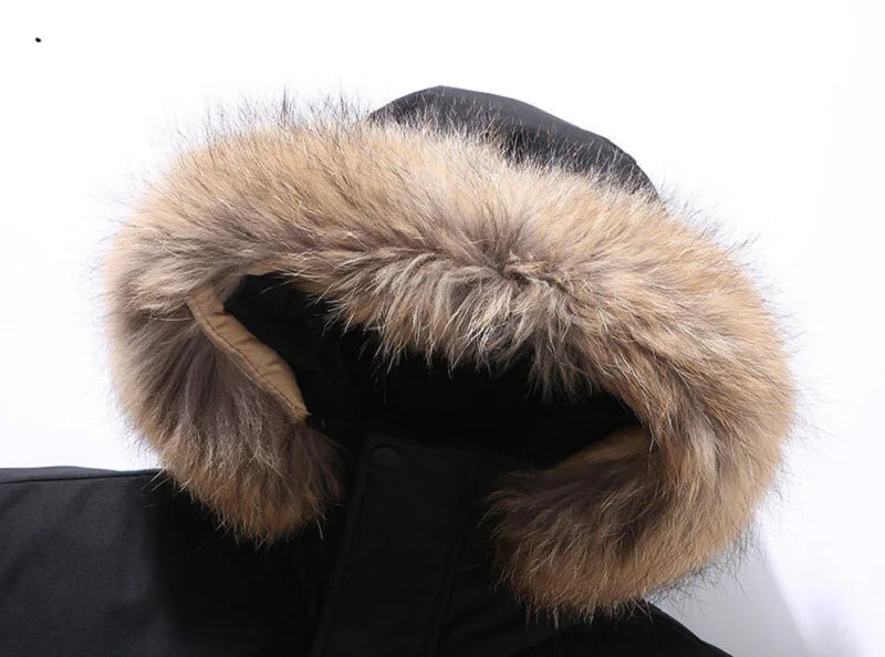Close-up of a black coat with a fur-lined hood on a white background