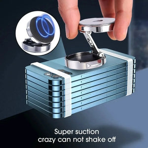 Metallic device with suction cup being held by a hand on a dark background