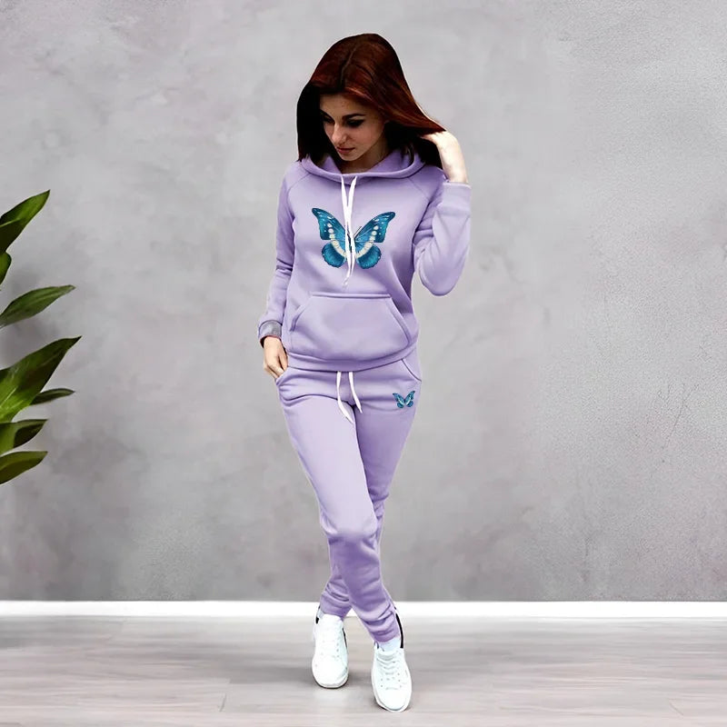 Woman wearing a lavender tracksuit with butterfly designs against a gray background