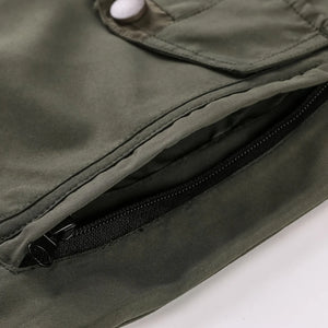 Close-up of a green jacket with a zipper pocket on a white background