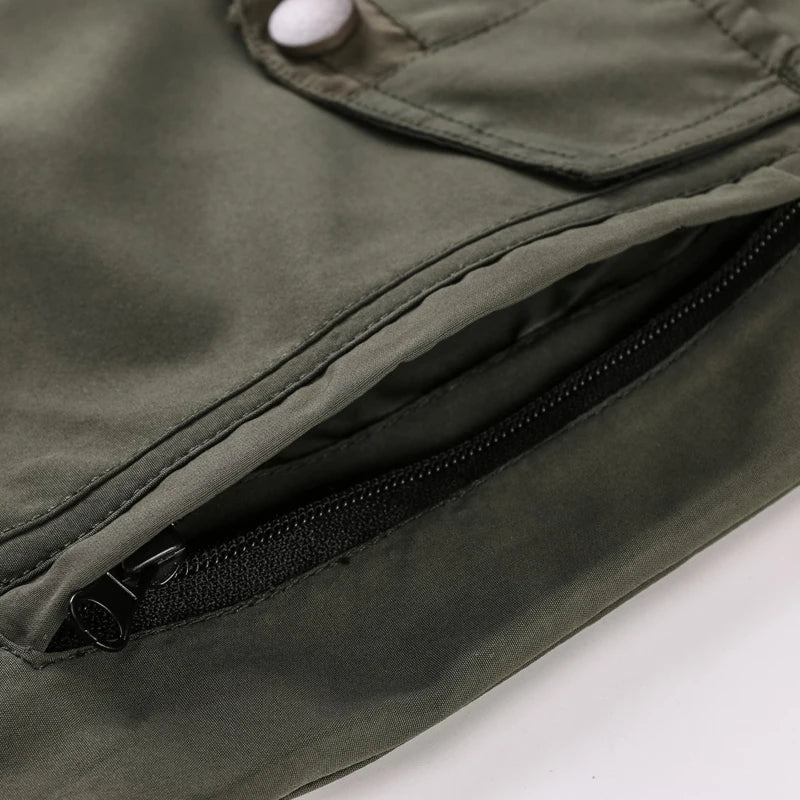 Close-up of a green jacket with a zipper pocket on a white background