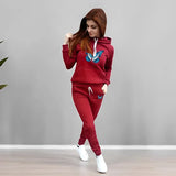 Woman wearing a red tracksuit with a butterfly design on a gray background