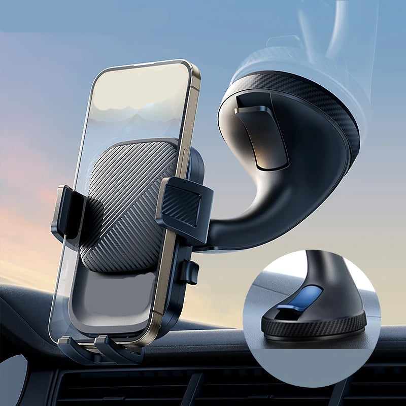 Car phone holder with suction cup and lever on a car dashboard, with a blurred outdoor background.