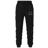 Black sweatpants with a heart and heartbeat design on a white background